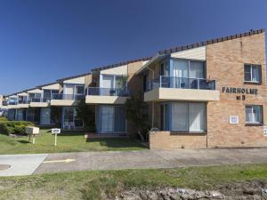 a brick building with a sign on the side of it at Fairholme 12 in Tuncurry