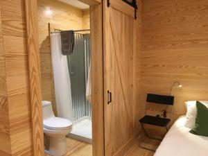 a bathroom with a toilet in a wooden room at Little River Cabin in Sparta