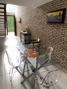a glass table and chairs in a room with a brick wall at Madre Natura in Asuncion