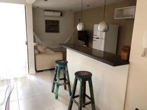 a kitchen with two stools and a counter with a refrigerator at Madre Natura in Asuncion