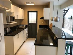 a kitchen with white cabinets and black counter tops at Madre Natura in Asuncion