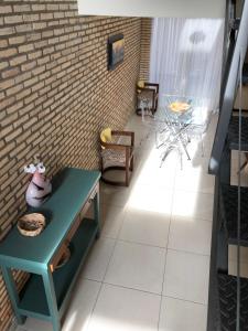 a room with a green table and a brick wall at Madre Natura in Asuncion
