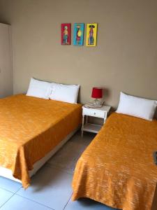 a bedroom with two beds and a table with a lamp at Madre Natura in Asuncion