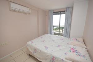 a bed in a room with a window at Leme Penthouse Apartment in Fortaleza