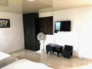 a bedroom with a bed and a tv and a fan at Finca El Bazar in Montenegro