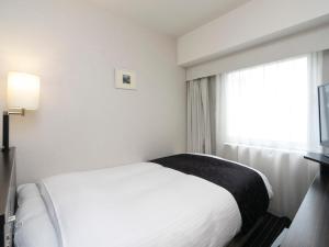 1 dormitorio con cama blanca y ventana en APA Hotel Yodoyabashi Ekimae, en Osaka