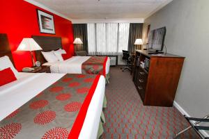 a hotel room with two beds and a television at Ramada Hotel & Conference Center by Wyndham Lewiston in Lewiston