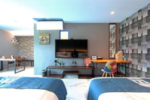 大漢村的住宿－白色地中海，一间卧室配有两张床和一台平面电视