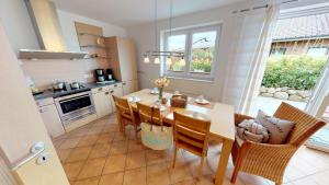 a kitchen and dining room with a table and chairs at Feriendorf Südstrand Haus 09 in Pelzerhaken