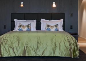 a bedroom with a green bed with four pillows at Port Phillip Estate in Red Hill South