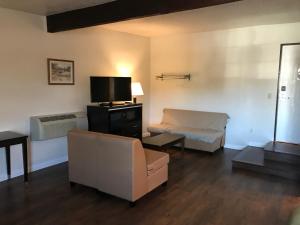 a living room with a couch and a tv at Manhattan Inn & Suites in Manhattan Beach