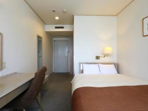 ein Hotelzimmer mit einem Bett und einem Schreibtisch in der Unterkunft Chino Sky View Hotel in Chino