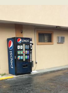 a pepsi machine sitting in front of a building at Hallmark Motel in Cinnaminson