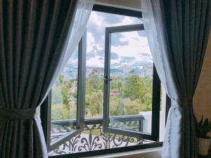 d'une fenêtre avec vue sur un balcon. dans l'établissement Le Grey Dalat Hotel, à Đà Lạt