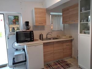 a small kitchen with a sink and a microwave at CENTRAL TOWN STUDIO ON POROS in Poros
