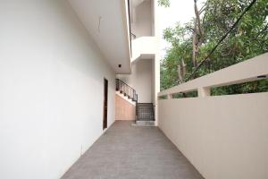 un pasillo de una casa con paredes blancas y árboles en RedDoorz near Taman Palem en Yakarta