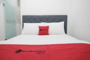 A bed or beds in a room at RedDoorz near Taman Palem