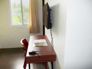 a room with a desk with a television and a table at Abrhys Ridge Inn in Coron