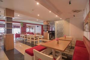 a restaurant with tables and chairs in a room at RedDoorz near Setrasari Mall 2 in Bandung