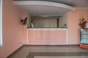 um quarto com uma parede rosa com flores em RedDoorz near Setrasari Mall 2 em Bandung