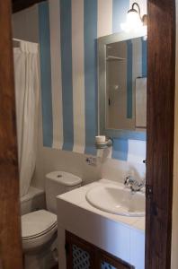 W łazience znajduje się umywalka, toaleta i lustro. w obiekcie Casa Rural con encanto "Los Postigos" w mieście Baños de Montemayor