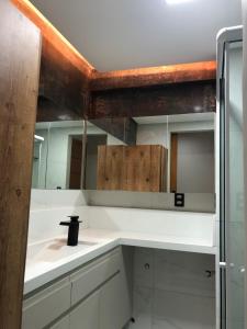 a bathroom with a sink and a mirror at Studio Lux West Flat in Mossoró