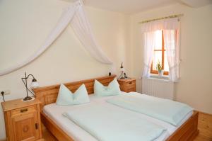 Schlafzimmer mit einem großen weißen Bett und einem Fenster in der Unterkunft Landhotel Gemeindeschänke in Wanfried