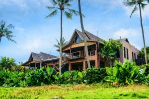 a house with palm trees in front of it at Villa Tao in Tabanan