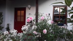 a house with a red door and a bunch of flowers at Ruhiges Apartment Nürnberg Süd Ost - Nähe Messe - mit Wallbox in Nürnberg