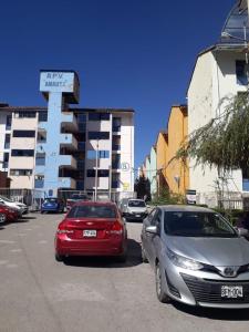 dos autos estacionados en un estacionamiento frente a un edificio en Piso Holbie Cusco, en Cusco