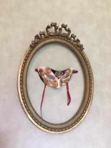 a picture of a mask in a gold frame at Le Plein Air in Saint-Étienne-au-Mont