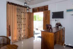 a living room with a television and a statue on a table at Lavista Holiday Bungalow in Wellawaya