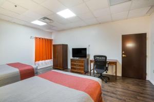 a bedroom with a bed and a television at Budgetel Inns & Suites - Atlanta Galleria Stadium in Atlanta