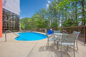 a patio area with chairs, tables and a pool at Budgetel Inns & Suites - Atlanta Galleria Stadium in Atlanta