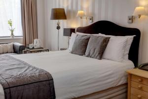 a bedroom with a large bed with white sheets and pillows at Best Western Princes Marine Hotel in Brighton & Hove