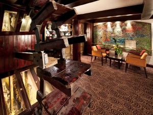 a living room with a table and chairs and a painting at Mercure Perth Hotel in Perth