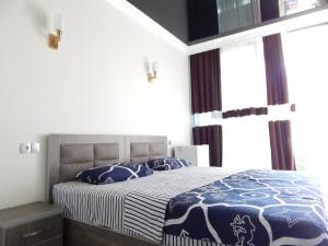 um quarto com uma cama com almofadas azuis e brancas em Guesthouse "Earth Center" em Kobuleti