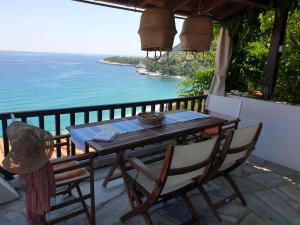 a wooden table and chairs on a balcony with the ocean at All about view Agios Ioannis Papa Nero in Agios Ioannis Pelio