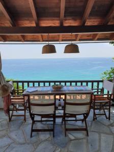 a table and chairs on a patio with a view of the ocean at All about view Agios Ioannis Papa Nero in Agios Ioannis Pelio
