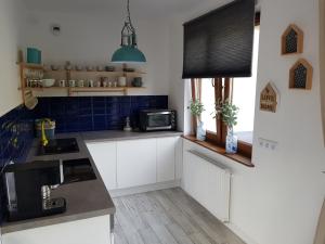 Apartament z widokiem في كارباش: مطبخ به دواليب بيضاء وبلاط ازرق