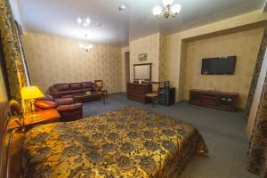 a hotel room with a bed and a couch and a television at Angara-Prioritet Hotel in Angarsk