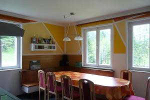 een eetkamer met een houten tafel en stoelen bij Waldcamp Frank in Wildalpen