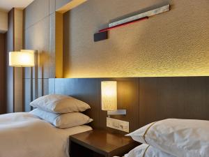 Sheraton Miyako Hotel Osaka tesisinde bir odada yatak veya yataklar