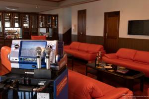 a waiting room with orange couches and a tv at Miyakojima White House in Miyako-jima +33 photos