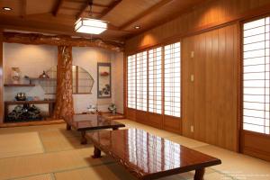 uma sala de estar com paredes de madeira e janelas grandes em Miyakojima White House em Ilhas Miyako