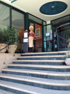 une statue debout en face d'un bâtiment avec des escaliers dans l'établissement Hotel Pina Ristorante, à Isola del Gran Sasso dʼItalia