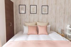 a bedroom with a white bed with pink pillows at FDS Liberta in Osaka
