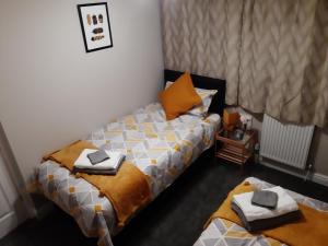 ein Schlafzimmer mit 2 Betten und Handtüchern darauf in der Unterkunft Sunny Lynn in Oldham