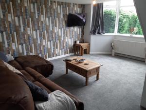 a living room with a couch and a coffee table at Sunny Lynn in Oldham