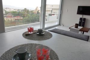 a table with two coffee cups and a view of a balcony at AllSeasonsApartment in Kalamata